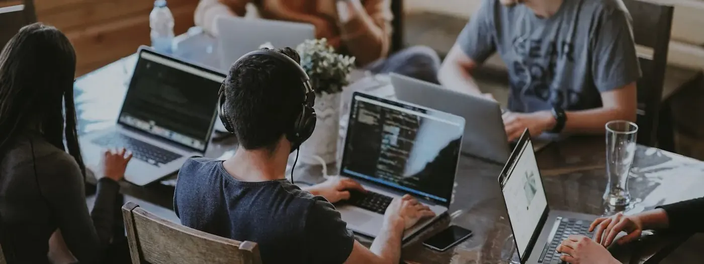Team collaborating around a laptop in a modern office